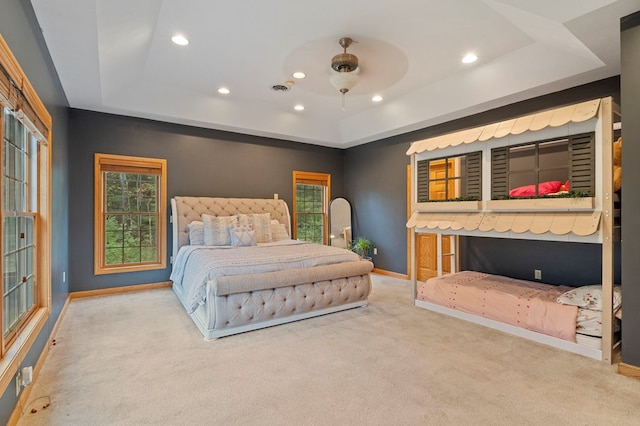 bedroom with carpet flooring, ceiling fan, and a raised ceiling