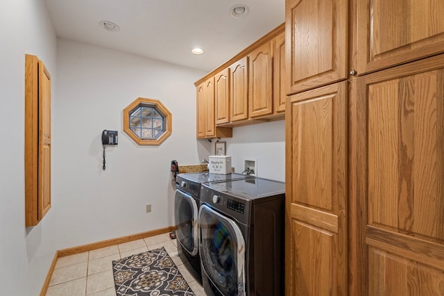 laundry area with cabinets, washing machine and dryer, and light tile patterned flooring