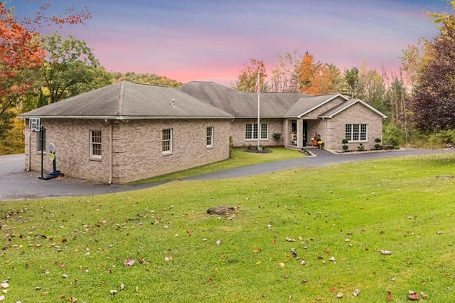 back house at dusk with a lawn