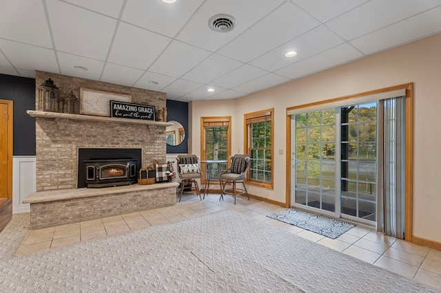 sitting room featuring tile patterned flooring and a wood stove