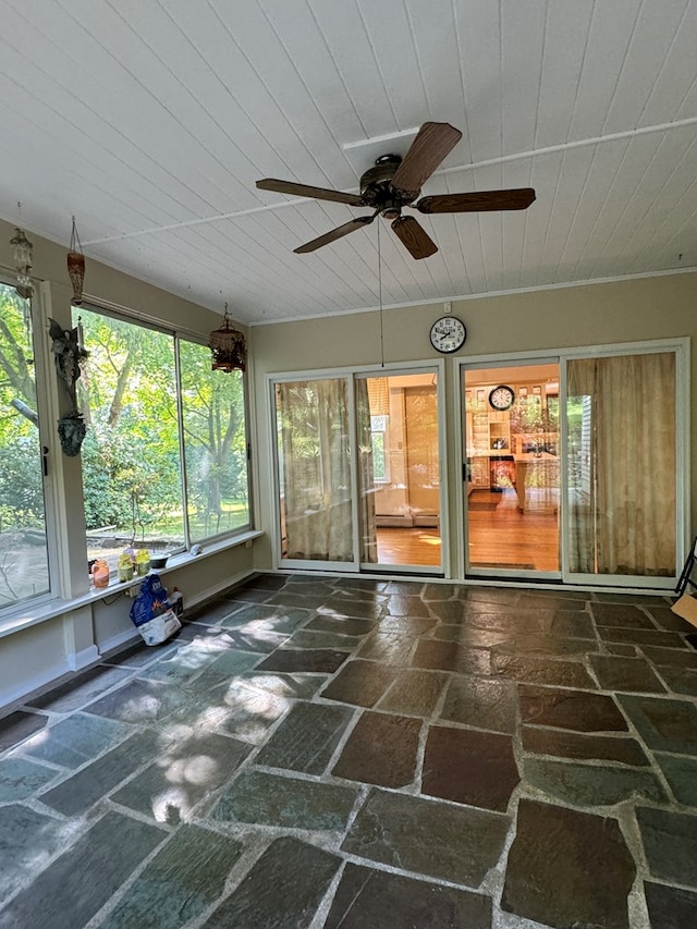 unfurnished sunroom featuring ceiling fan