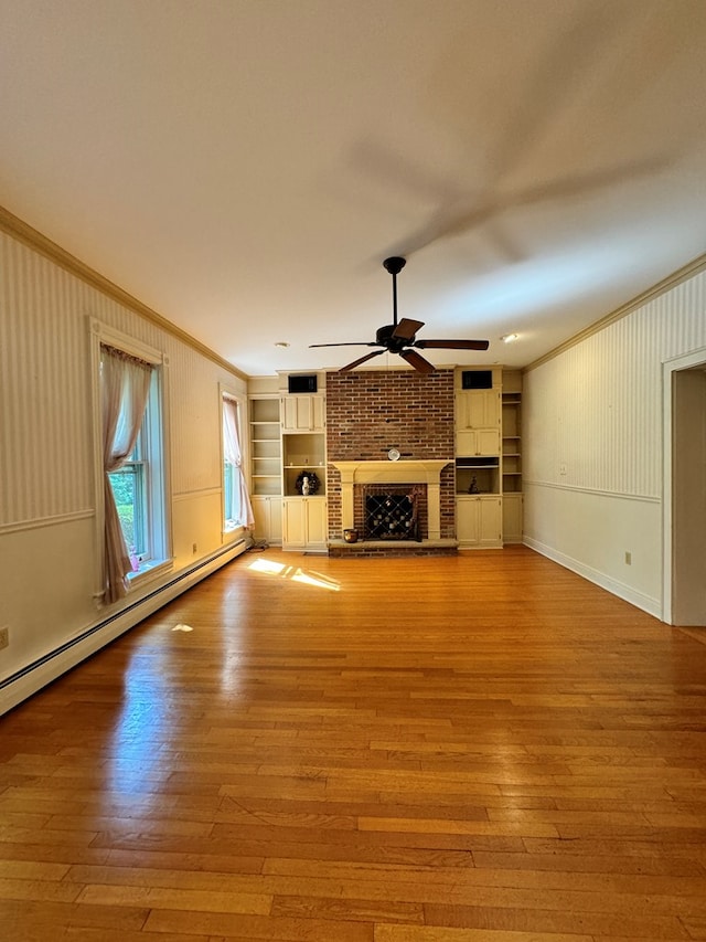 unfurnished living room featuring a baseboard radiator, a brick fireplace, built in features, crown molding, and light wood-type flooring