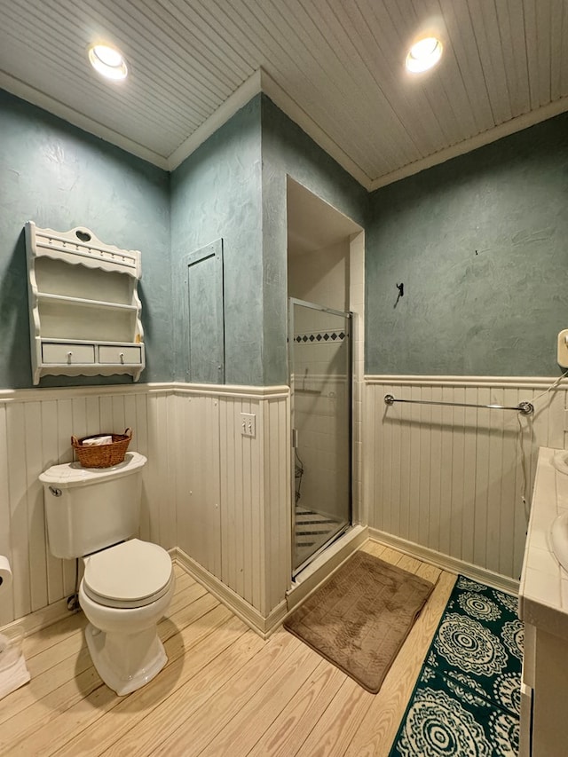 bathroom featuring vanity, hardwood / wood-style flooring, toilet, and an enclosed shower