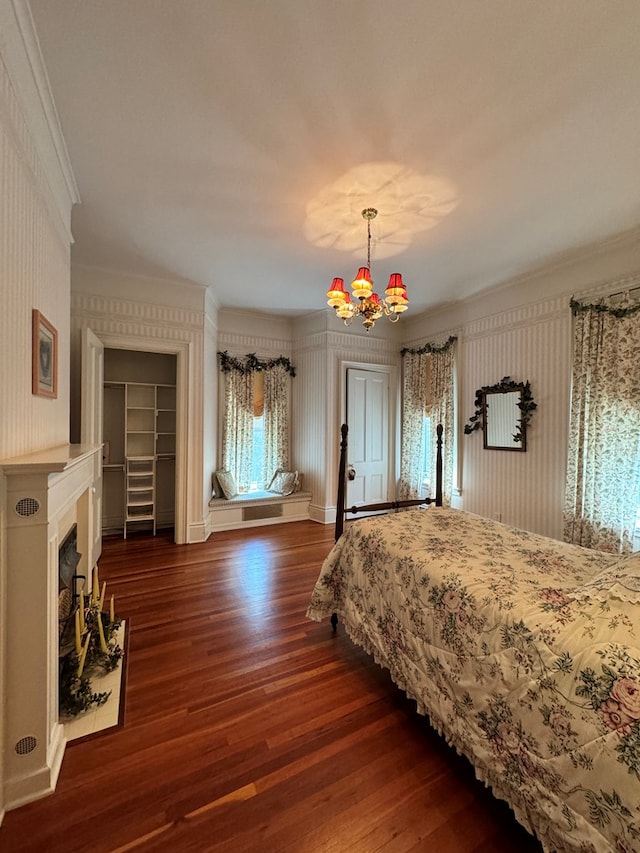 bedroom with dark hardwood / wood-style floors, ornamental molding, and a chandelier