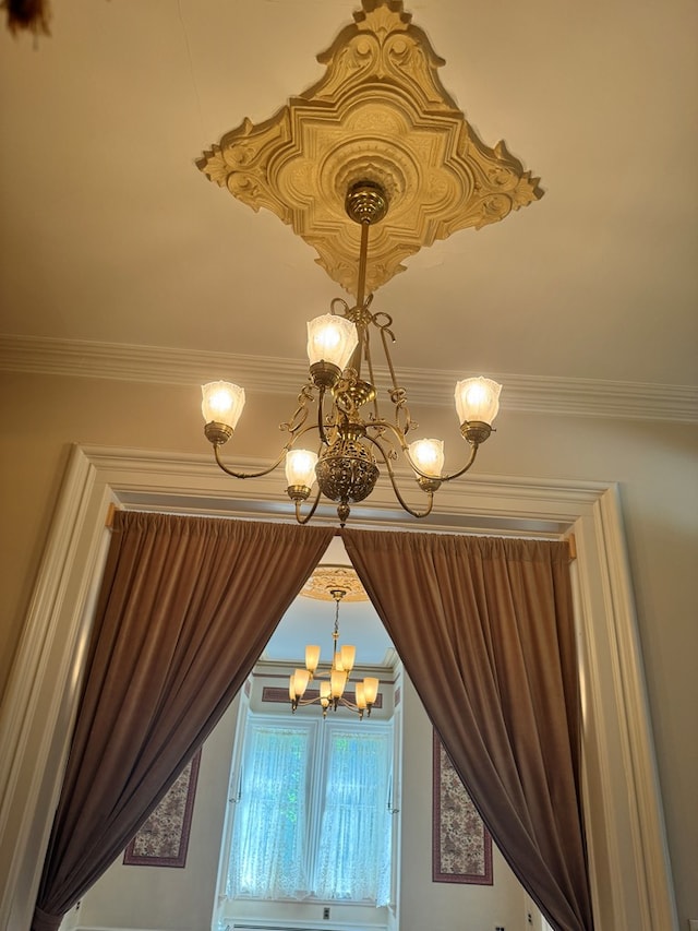 interior details with crown molding and a chandelier