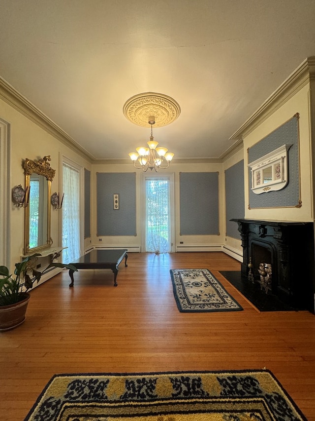 game room featuring hardwood / wood-style flooring, a wood stove, and an inviting chandelier