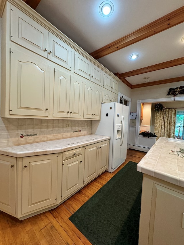 kitchen featuring beam ceiling, tasteful backsplash, tile counters, and light hardwood / wood-style floors