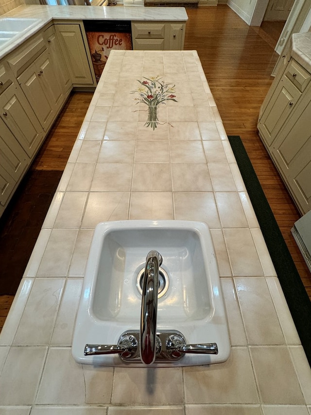 details with cream cabinetry, dishwashing machine, and sink