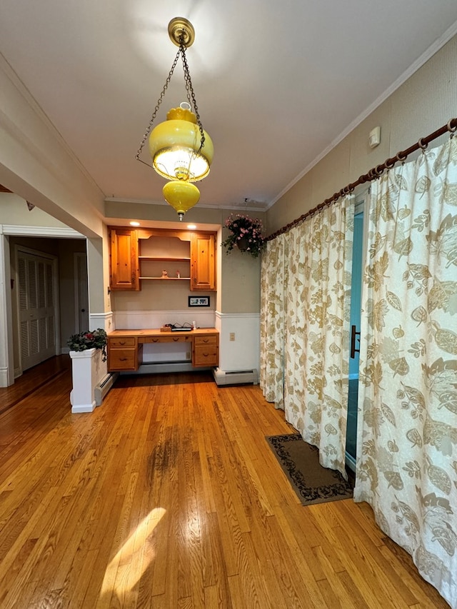 kitchen featuring light wood-type flooring, crown molding, and a baseboard heating unit