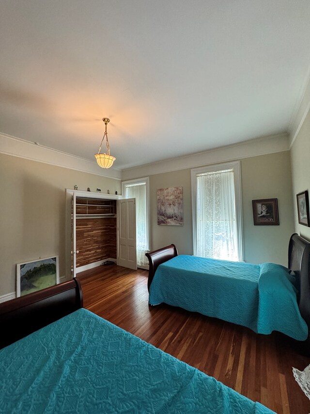 bedroom featuring dark hardwood / wood-style floors and ornamental molding