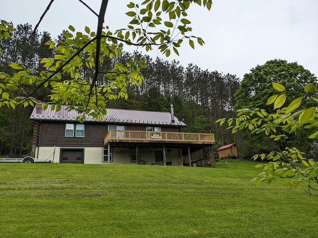 153 Pinneo Hill Rd, Oswayo, PA 16915 - rear view of house with a lawn, an attached garage, a wooden deck, and metal roof