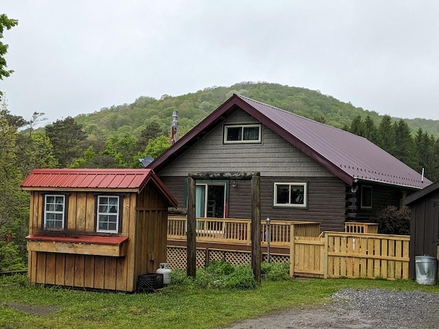 153 Pinneo Hill Rd, Oswayo, PA 16915 - rear view of house with a view of trees, metal roof, and a wooden deck