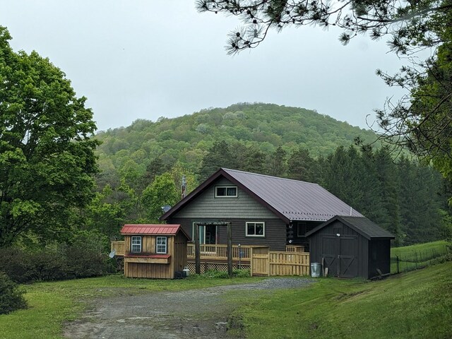 153 Pinneo Hill Rd, Oswayo, PA 16915 - back of property featuring a wooded view, a wooden deck, a lawn, and driveway