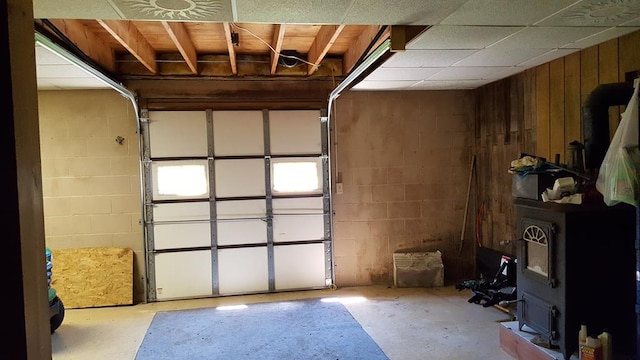 153 Pinneo Hill Rd, Oswayo, PA 16915 - garage featuring concrete block wall, wood walls, and a wood stove