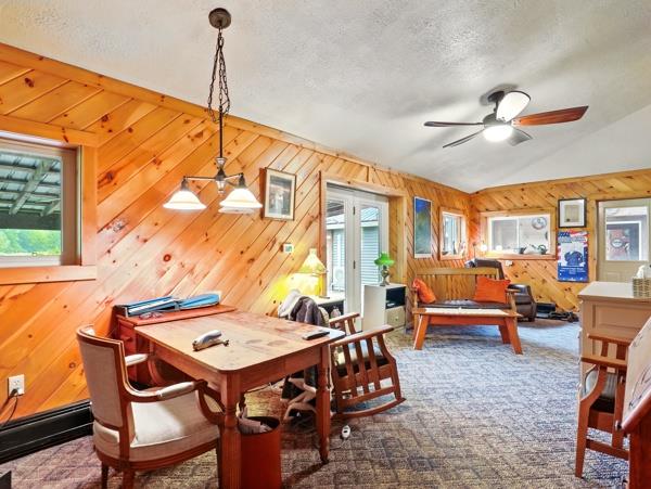 175 Rte 467, Wysox, PA 18854 - dining room with a ceiling fan, wood walls, vaulted ceiling, a textured ceiling, and carpet floors