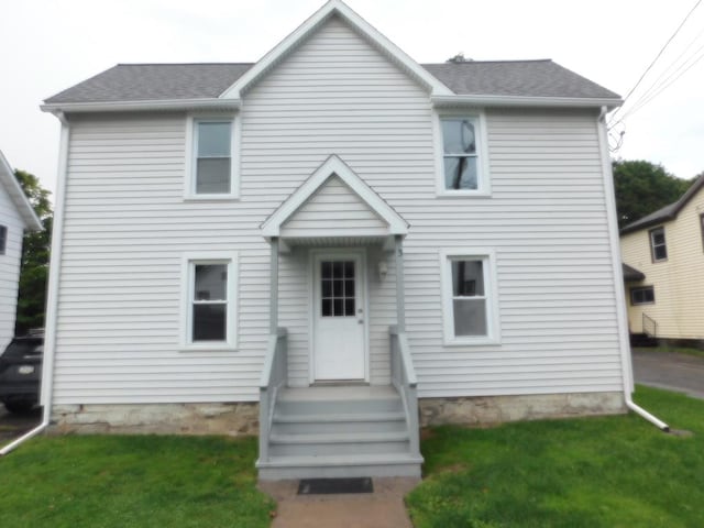 rear view of house featuring a yard