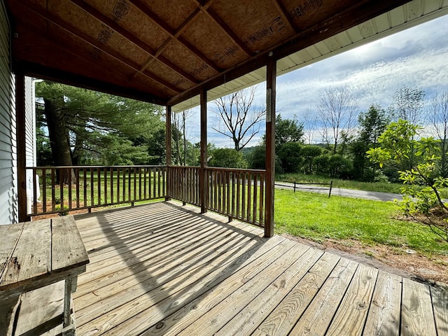 wooden deck featuring a lawn