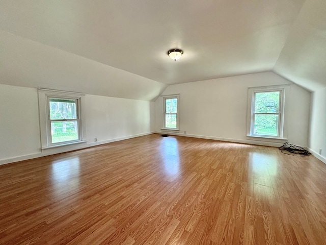 additional living space with lofted ceiling and light hardwood / wood-style flooring