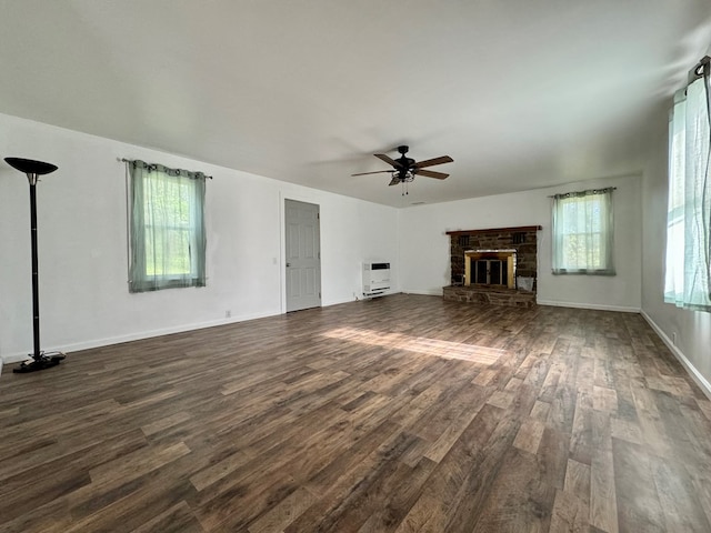 unfurnished living room featuring ceiling fan, heating unit, and dark hardwood / wood-style flooring