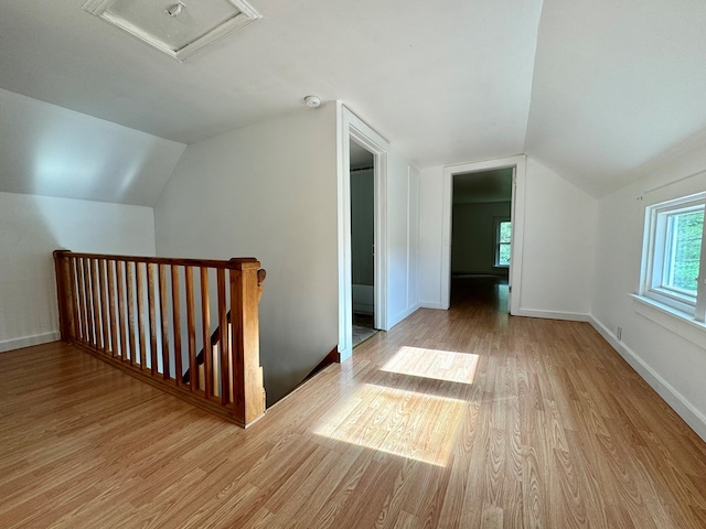 additional living space with lofted ceiling and light hardwood / wood-style floors