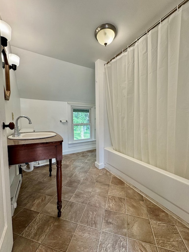 bathroom with vaulted ceiling, sink, baseboard heating, and shower / bath combo with shower curtain