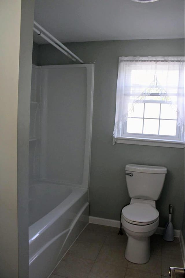 bathroom featuring tile patterned flooring, shower / tub combination, and toilet