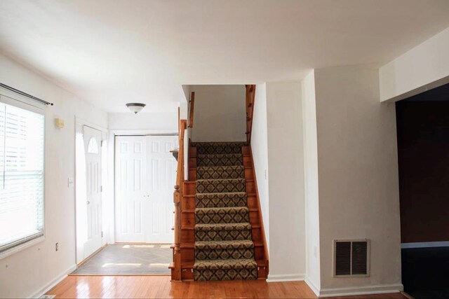 stairs with wood-type flooring and a wealth of natural light