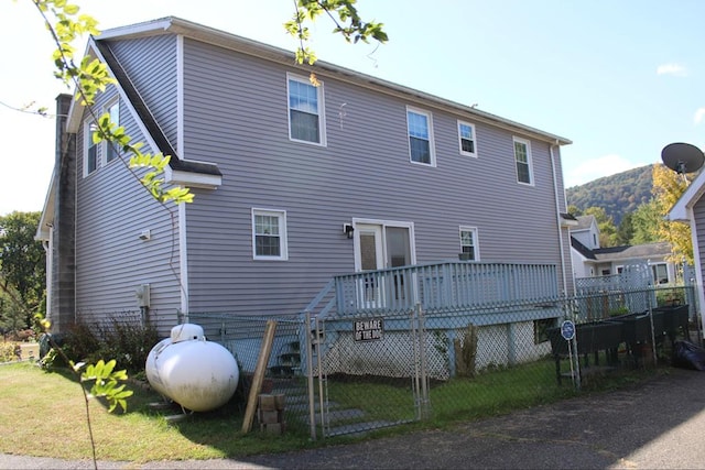 back of property with a deck with mountain view