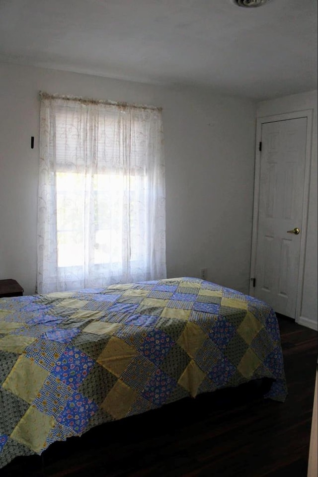 bedroom with dark hardwood / wood-style floors