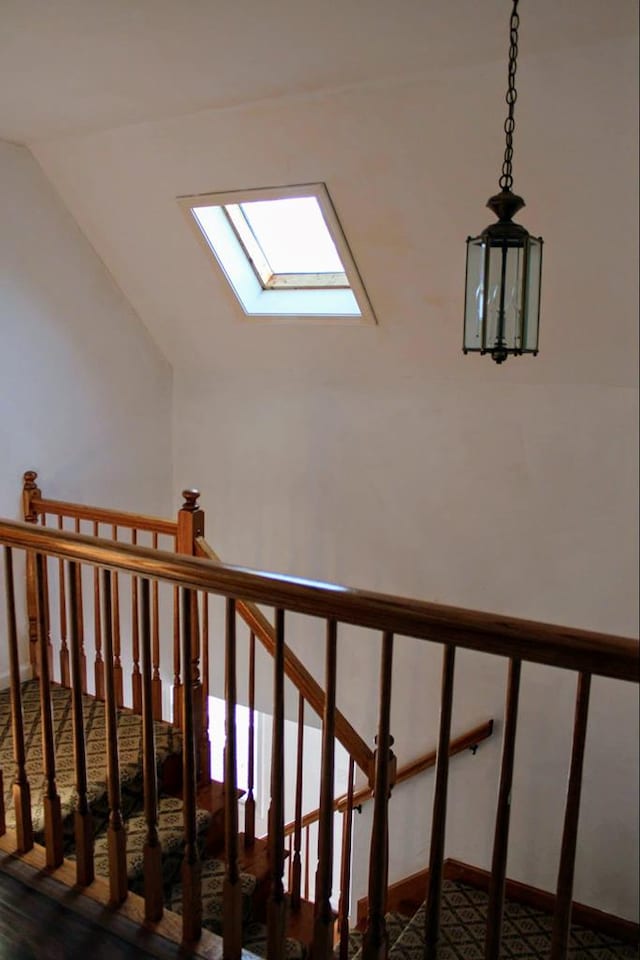 stairs with lofted ceiling with skylight