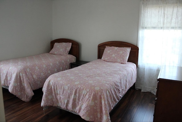 bedroom with dark hardwood / wood-style flooring