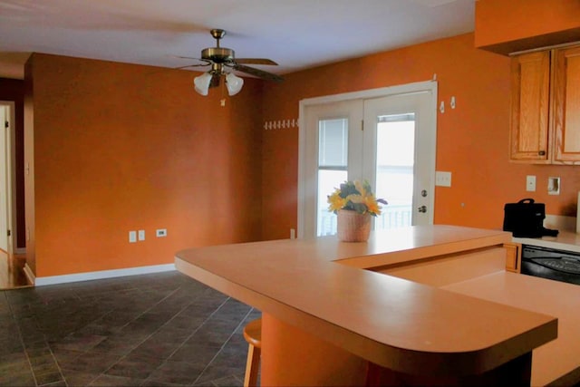 kitchen featuring ceiling fan, light brown cabinetry, and black dishwasher