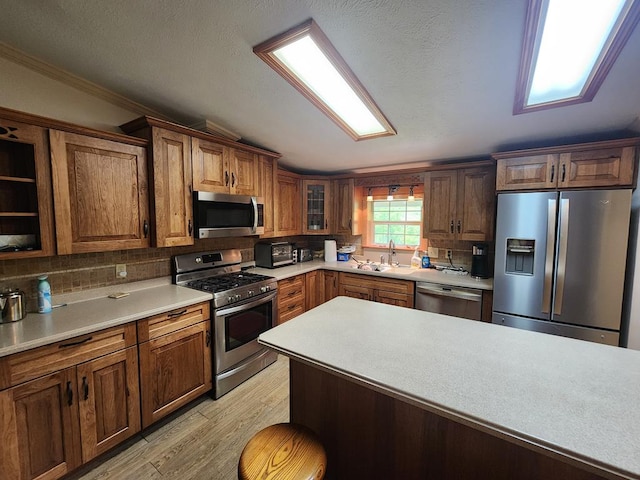 151 Ice Mine Rd, Coudersport, PA 16915 - kitchen featuring appliances with stainless steel finishes, light wood-type flooring, tasteful backsplash, light countertops, and glass insert cabinets