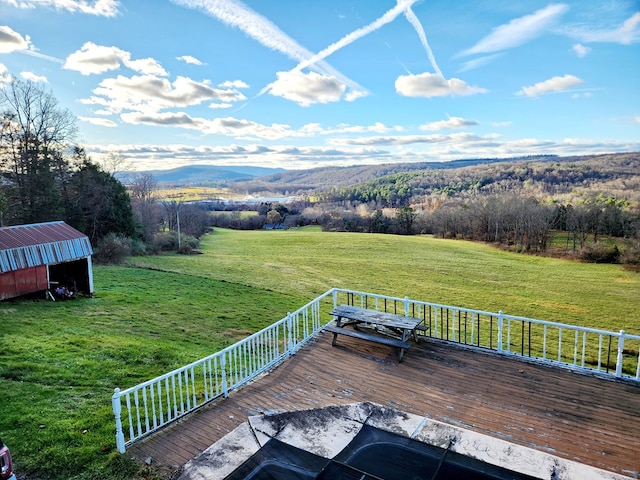 deck with a lawn, a mountain view, and an outbuilding