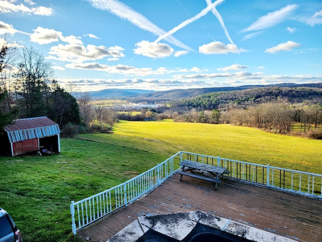 wooden terrace with a mountain view, an outbuilding, and a lawn