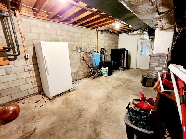 basement featuring white refrigerator and heating unit