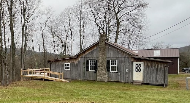 rear view of house featuring a lawn and a wooden deck