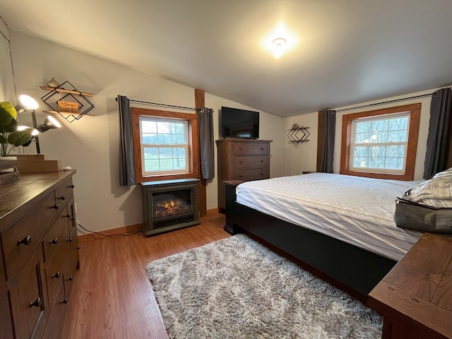 bedroom featuring light hardwood / wood-style floors and vaulted ceiling