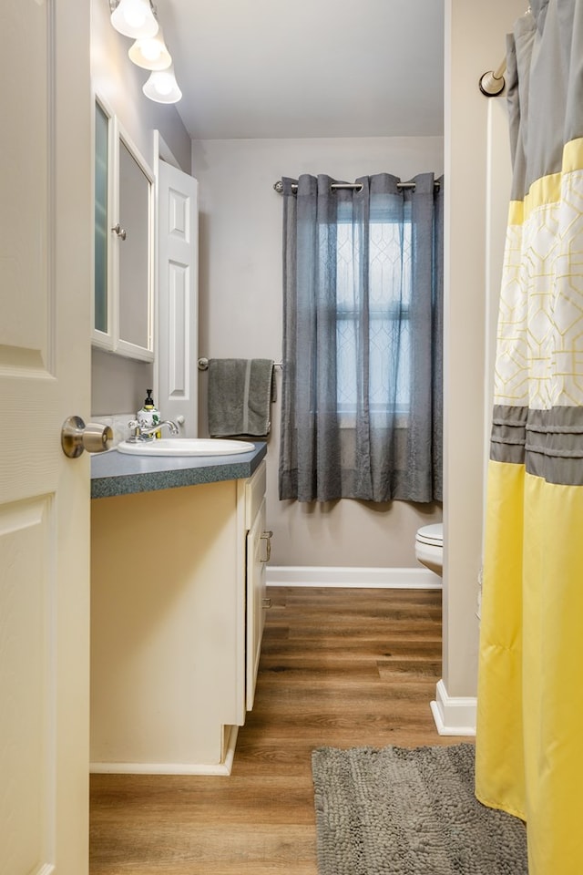 bathroom with toilet, vanity, and hardwood / wood-style flooring