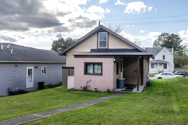 rear view of house featuring a lawn