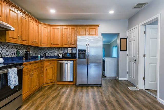 kitchen with washer / clothes dryer, ornamental molding, dark hardwood / wood-style floors, and appliances with stainless steel finishes