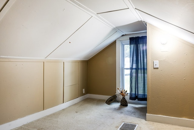 additional living space with light colored carpet and vaulted ceiling