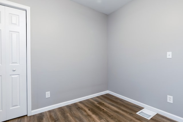 empty room with dark hardwood / wood-style flooring