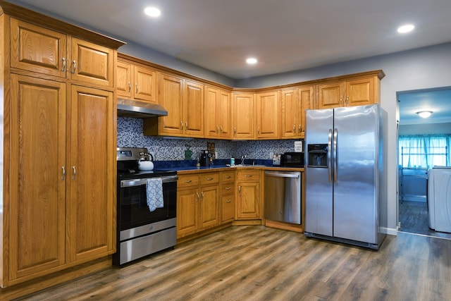 kitchen with backsplash, stainless steel appliances, sink, washer / clothes dryer, and dark hardwood / wood-style floors