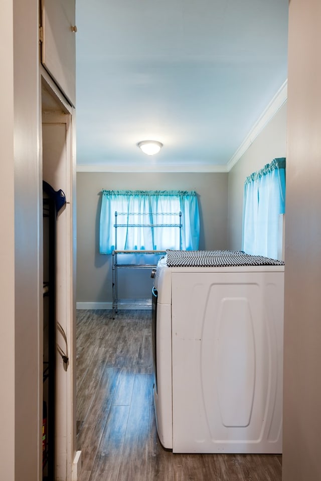 laundry room with hardwood / wood-style flooring, washer / dryer, and crown molding