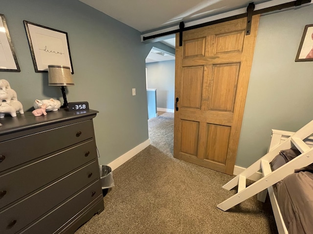 hallway with dark colored carpet and a barn door