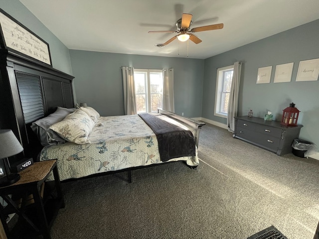 carpeted bedroom featuring multiple windows and ceiling fan