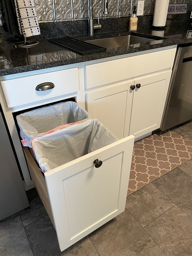 interior space with stainless steel dishwasher, decorative backsplash, white cabinetry, and sink