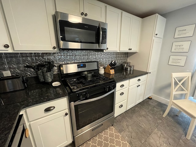 kitchen featuring tasteful backsplash, dark stone countertops, white cabinets, and stainless steel appliances