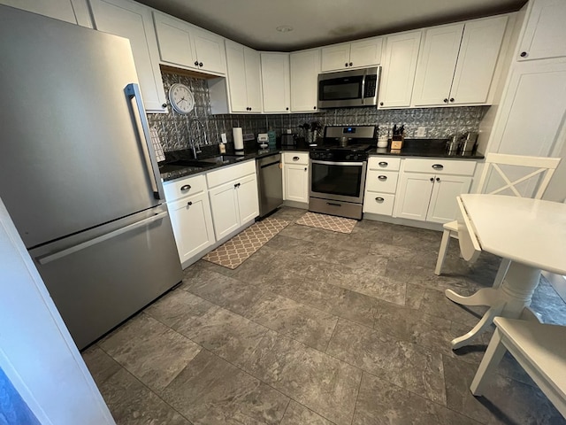 kitchen featuring decorative backsplash, white cabinetry, sink, and appliances with stainless steel finishes